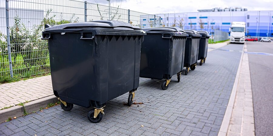 black dumpsters with wheels in the walkway